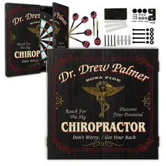 Custom chiropractor dartboard set with cabinet doors open, steel tip darts, mounting hardware, and included accessories.