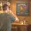 Man drinking whiskey while playing darts in a home bar featuring a personalized Bourbon Bar dartboard cabinet with custom name design, perfect for man cave or whiskey bar decor.